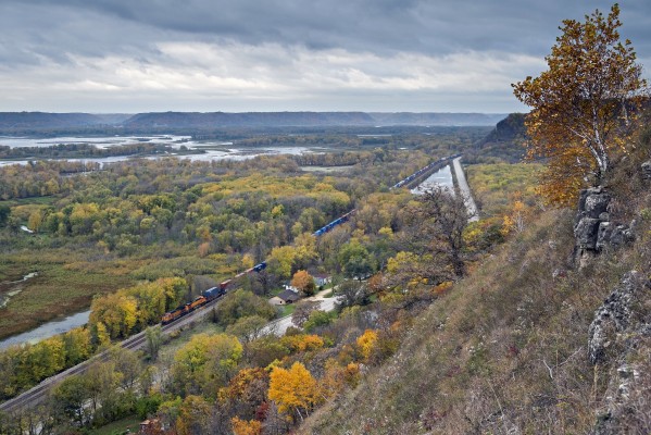 BNSF Railway eastbound doublestack container train running down the Mississippi River through fall color near De Soto, Wisconsin, on October 17, 2014.