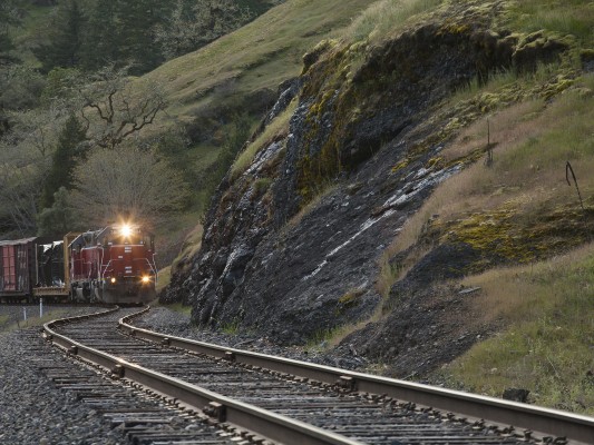 Central Oregon and Pacific Railroad freight train rolling along the jointed rail of the former Southern Pacific Siskiyou Line near the north end of Cow Creek Canyon on April 8, 2010.