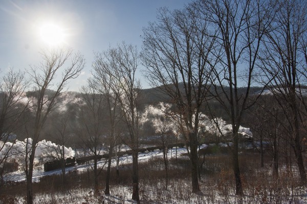 Two narrow-gauge 0-8-0 C2 steam locomotives pull and push an eight-car loaded coal train up the steep grade west of Lixin, Heilongjiang, China, on November 30, 2005.