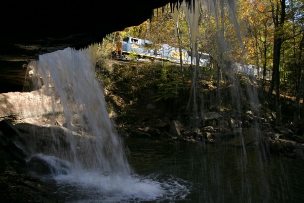 CSX locomotives pass a waterfall on Meadow Creek, near the community of Meadow Creek, West Virginia, in the New River Gorge. The locomotives just delivered the first half of a coal train to the main line junction and are returning to Rainelle for the second half.