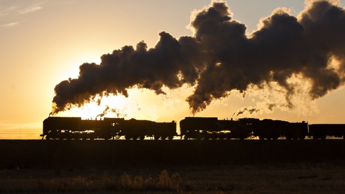 Two Jitong Railway QJ steam locomotives lead an eastbound freight train out of Daban, Inner Mongolia, China, just after sunrise on a November 2005 morning.