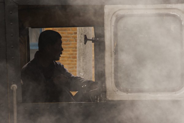 Fireman in the cab of narrow-gauge 0-8-0 C2 steam locomotive 04 in the village of Xiahua on September 27, 2005.