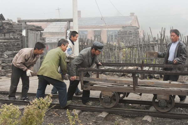 After the morning coal train passed, the section gang in Tuoyaozi got to work, loading a piece of rail onto a rail cart. September 27, 2005.