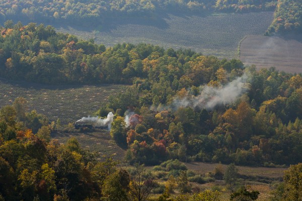 Autumn colors glow in the afternoon sun in the hills east of Tuoyaozi, where an empty coal train of the Huanan Forestry Railway climbs the grade toward the summit on September 28, 2005.