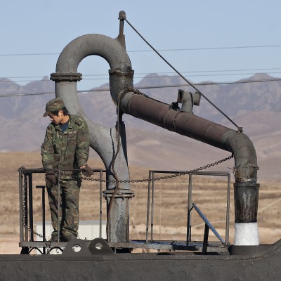 A young Jitong Railway workers fills the tender of a QJ steam locomotive in Daban, Inner Mongolia, China, in November 2005.