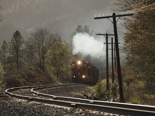 Central Oregon and Pacific Railroad GP38-3 locomotives throttle up as they bring their train out of Cow Creek Canyon in the evening sun near Riddle, Oregon, on April 8, 2010.