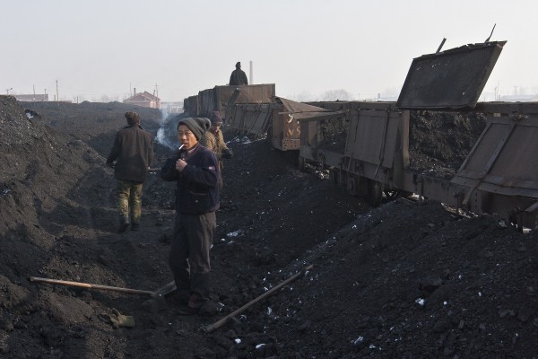 The Huanan Forestry Railway ended in the city of Huanan, where workers shoveled coal by hand from the narrow-gauge gondola cars into piles for transfer into standard-gauge trains. November 27, 2005