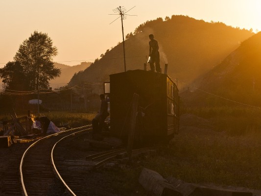 As the sun sets over the village of Tuoyaozi, workers on the narrow-gauge Huanan Forestry Railway prepare for dinner on September 27, 2005.