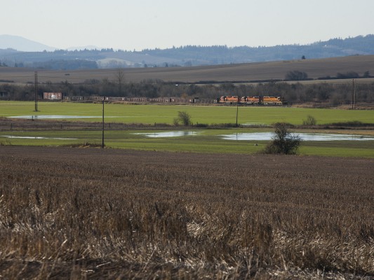 Portland and Western's Westsider freight train rolls north through fields near McMinnville, Oregon, on an unusually clear December 2, 2009, although the fields still hold puddles from the more typical rain of late fall.