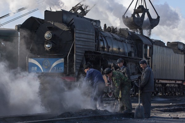 Jitong Railway QJ steam locomotive no. 7143 receives a load of coal at Daban, Inner Mongolia, China, in November 2005, as several workers look on.