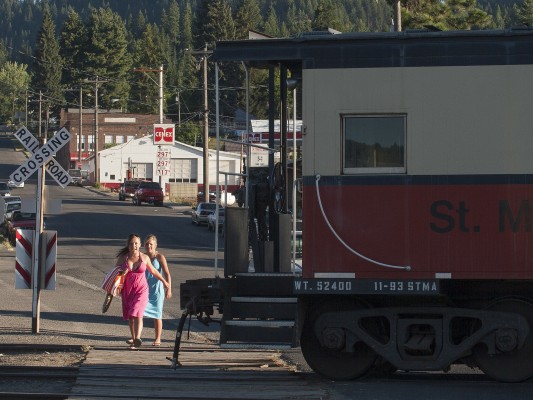 Two teenagers start across the tracks in downtown St. Maries, Idaho, as the caboose of the St. Maries River Railroad's inbound Clarkia Logger passes. The girls are heading for the town's popular waterpark on the St. Joe River on this warm July evening in 2007.