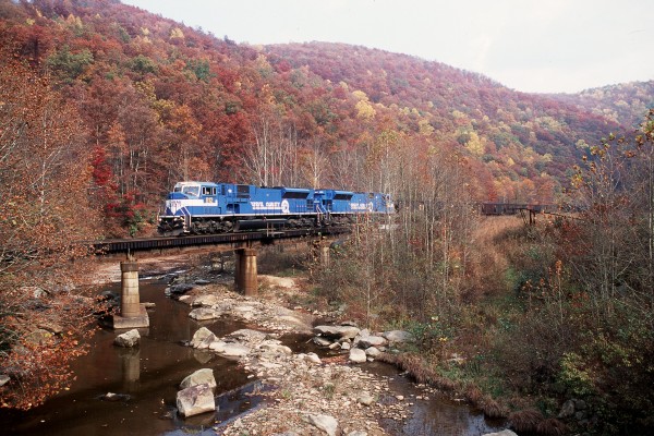 Two former Conrail SD80MACs lead an eastbound CSX coal train over Laurel Creek at the former mine site of Prestonia on the Cowen Subdivision, deep in the heart of West Virginia on October 21, 2000.