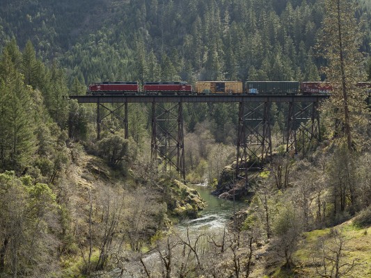 Central Oregon and Pacific freight train crossing Grave Creek on a steel viaduct south of Wolf Creek, Oregon, on April 8, 2010. This is the former Siskiyou Line of the Southern Pacific Railroad, and the first rail link between Oregon and California.