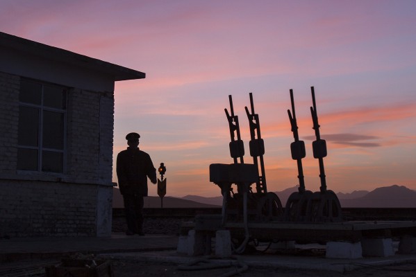 Jitong Railway switchman at the west end of the Baomutu siding in Inner Mongolia, China, at sunset on an October 2005 evening.