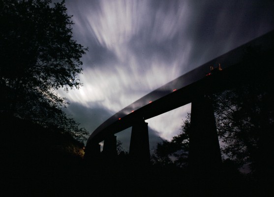 Clouds sweep through a moonlit night as an empty coal train crosses Pleasant Creek trestle on CSX's Cowen Subdivision, seven miles south of Grafton, West Virginia.