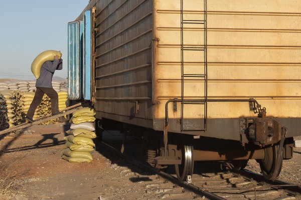 A worker loads a bag of rice into a boxcar in Lindong, Inner Mongolia, China, in November 2005.