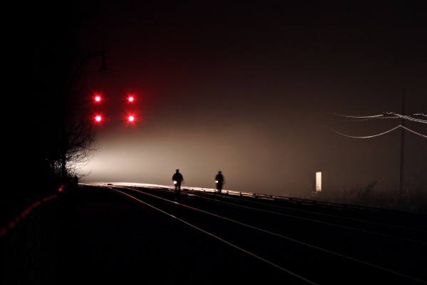 Two crew members from Amtrak's westbound "Cardinal," train no. 51, walk the train through malfunctioning absolute signals on CSX's New River Subdivision at Prince, West Virginia, illumiated by their train's headlight on the foggy night of April 30, 2004.