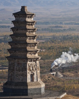 Westbound Jitong Railway freight train passing the 700-year-old pagoda in Lindong, Inner Mongolia, China.