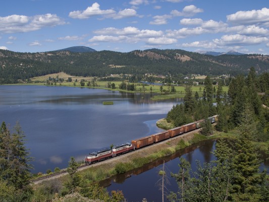 The St. Maries River Railroad's outbound Plummer Turn crosses a causeway at the southern edge of Benewah Lake with finished lumber for the Union Pacific interchange in Plummer. The train is on the former Milwaukee Road mainline just west of St. Maries, Idaho, on a bright July day in 2004.