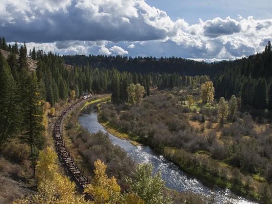It's a pristine fall day along the St. Maries River at Washburn, Idaho, in October 2008 as the St. Maries River Railroad's outbound Clarkia Logger rolls up the river with empties for the reload at Clarkia.