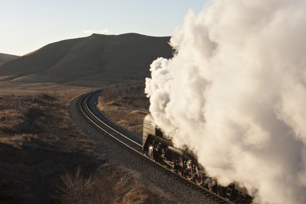 Steam shrouds a westbound QJ steam locomotive approaching Lindong.