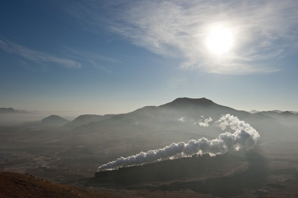 Two QJ steam locomotives lead a Jitong Railway westbound freight train through a sweeping curve just outside of Lindong, Inner Mongolia, China, in November 2005.