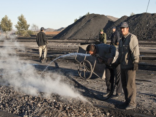 Jitong Railway worker takes a quick drink from the hose used to clean locomotive fireboxes at Daban.