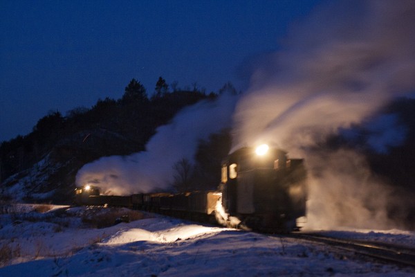Two narrow-gauge 0-8-0 C2 steam locomotives pull and push an eight-car loaded coal train out of Lixin in the predawn darkness of December 2, 2005.