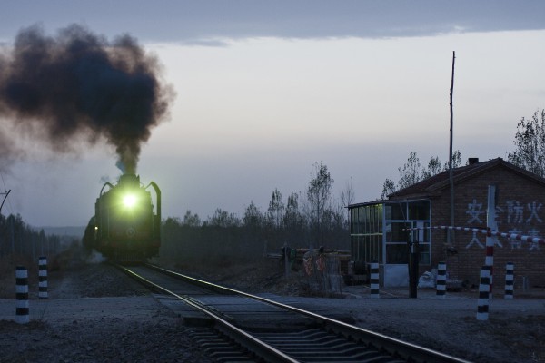 Eastbound Jitong Railway freight train approaching Baomutu, Inner Mongolia, China, as twilight descends on a cloudy day in October 2005.