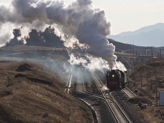 After meeting a freight train, a steam-powered passenger special pulls onto the Jitong Railway main line at Jingpeng Pass on a November afternoon in 2005.