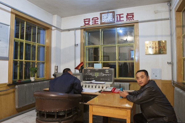 Two Jitong Railway workers inside the Gulumanhan station's office on an October night in 2005.