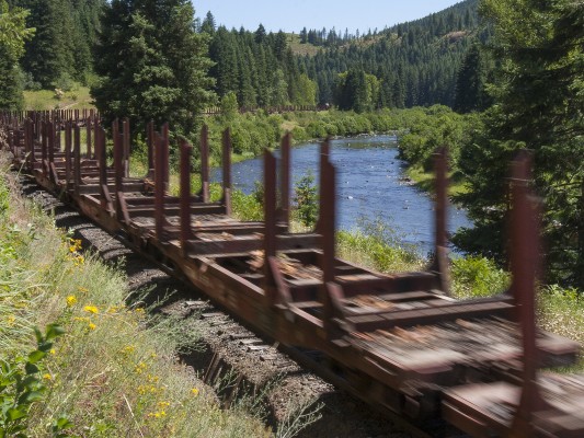 Former Milwaukee Road log cars roll up the St. Maries River in Idaho's panhandle on a July afternoon in 2005.