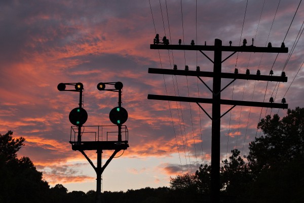 Baltimore & Ohio position light signals glow green against a pink sunset as Amtrak's westbound "Capital Limited" approaches on the Magnolia Cutoff near Paw Paw, West Virginia.