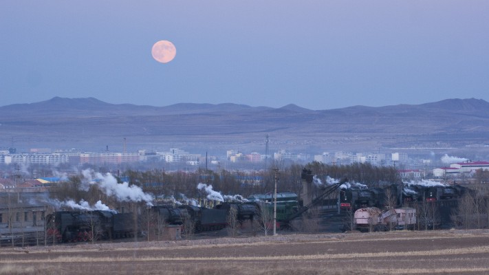 The full moon rises over the Jitong Railway's Chabuga engine terminal at Tianshan, Inner Mongolia, China, in November 2005.