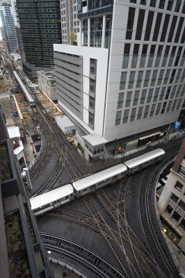 At Tower 18 on the Chicago L, in the northwest corner of the Loop, an outbound Brown Line train heads north while an inbound Pink Line train waits in the distance.