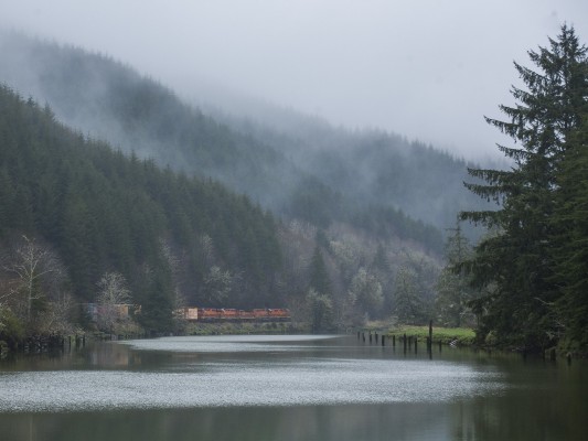 Mist rises over the Coast Range as Portland and Western's Toledo Hauler rolls east up the Yaquina River on the morning of March 31, 2011.