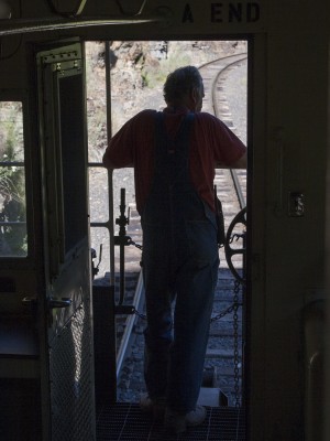 St. Maries River Railroad conductor Pat Hough watches the tracks recede from the backdoor of his caboose on the inbound Clarkia Logger in July 2005.