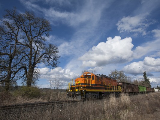 Portland and Western 1804 shoves a work train of ballast hoppers into a siding between Albany and Corvallis, Oregon, beneath a beautiful sky on March 3, 2009.