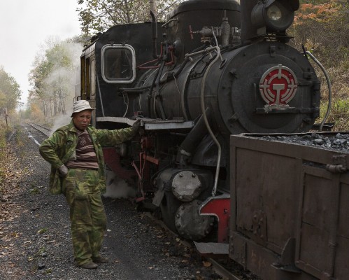 An engineer of the Huanan Forestry Railway poses with his 0-8-0 C2 locomotive at the summit just west of Lixin on September 29, 2005.