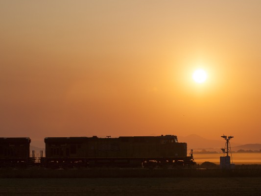 The rising sun silhouettes a Union Pacific locomotive and former Southern Pacific searchlight signals near Tangent, Oregon, on the morning of September 15, 2008.