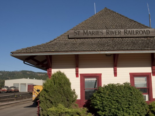 The St. Maries River Railroad's office in the former Milwaukee Road depot in St. Maries, Idaho. The railroad's two ex-Milwaukee Road SW12000 diesel switchers rest outside the three-stall engine house in the background.