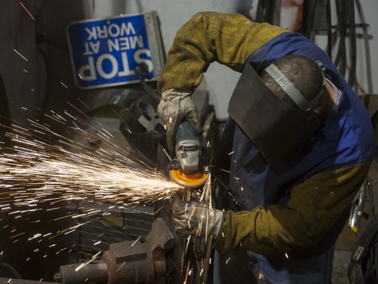 One of Portland and Western's diesel doctors grinds down a part inside the railroad's Albany shops on May 20, 2009. Shot on assignment for <i>Locomotive</i> magazine.