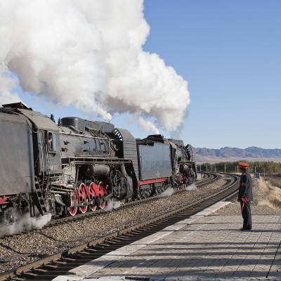 The Gulumanhan station agent watches the passage of an eastbound JItong Railway freight train on an October 2005 morning.