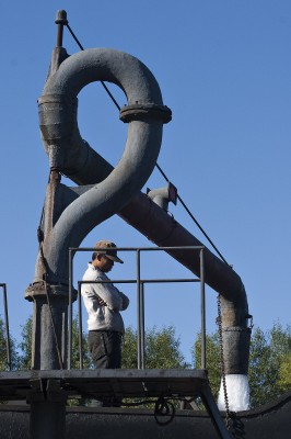 Jitong Railway worker waits as he fills the tender of a QJ steam locomotive at Daban on October 3, 2005.