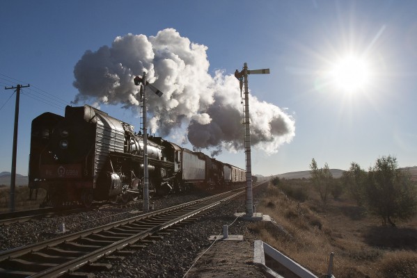 Two Jitong Railway QJ steam locomotives depart Chagganhada, Inner Mongolia, China, on an October morning in 2005.