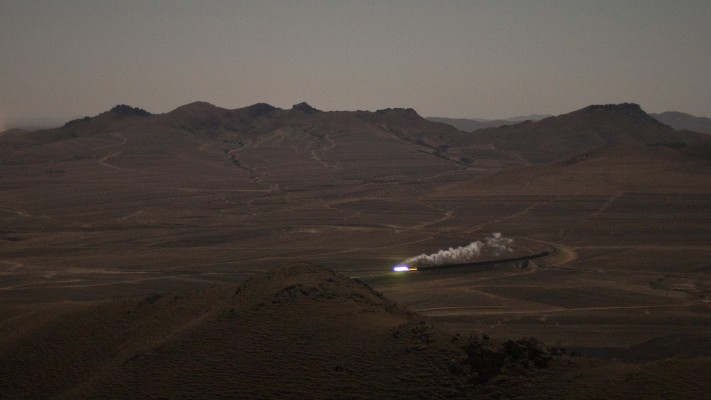 A westbound JItong Railway freight train sweeps through a curve near Lindong, Inner Mongolia, China, by the light of the full moon in November 2005.