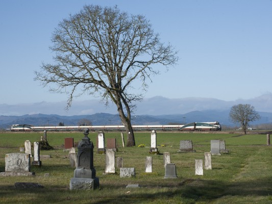 Amtrak <i>Cascades</i> passenger train north no. 504 passing the Independent Order of Odd Fellows cemetery near Harrisburg, Oregon, on the morning of February 27, 2010.