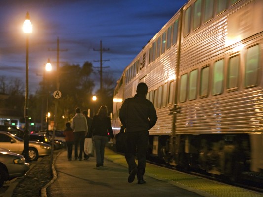 Passengers disembarking from an outbound Metra UP West Line train as it pulls out of Glen Ellyn, Illinois, at dusk on November 5, 2011.