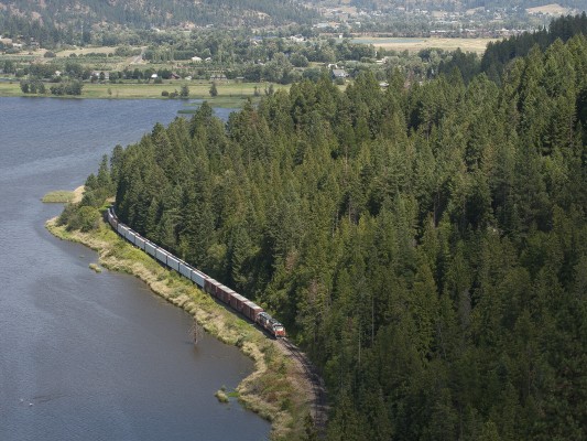 The St. Maries River Railroad's outbound Plummer Turn rolls along Benewah Lake just west of St. Maries, Idaho, in July 2007, with a long train of finished lumber for the Union Pacific interchange in Plummer.
