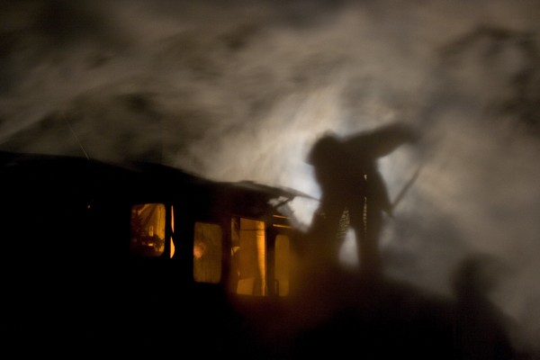 A fireman of the narrow-gauge Huanan Forestry Railway trims coal in the tender of an 0-8-0 C2 steam locomotive on a cold November night in Xiahua, Heilongjiang, China, in 2005.